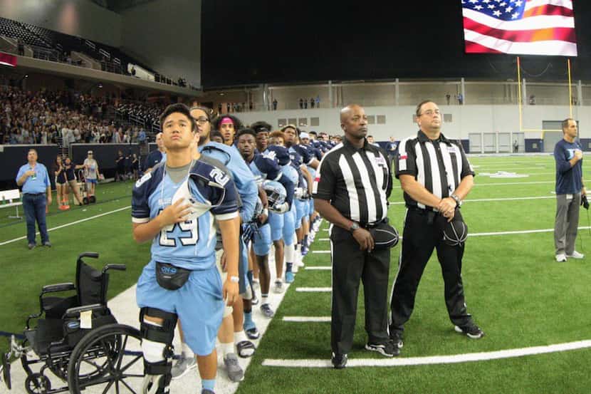 Hurst L.D. Bell junior Vita Tonga stands with his teammates for the National Anthem a day...