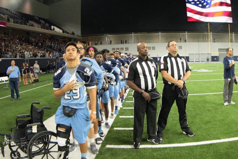 Hurst L.D. Bell junior Vita Tonga stands with his teammates for the National Anthem a day...