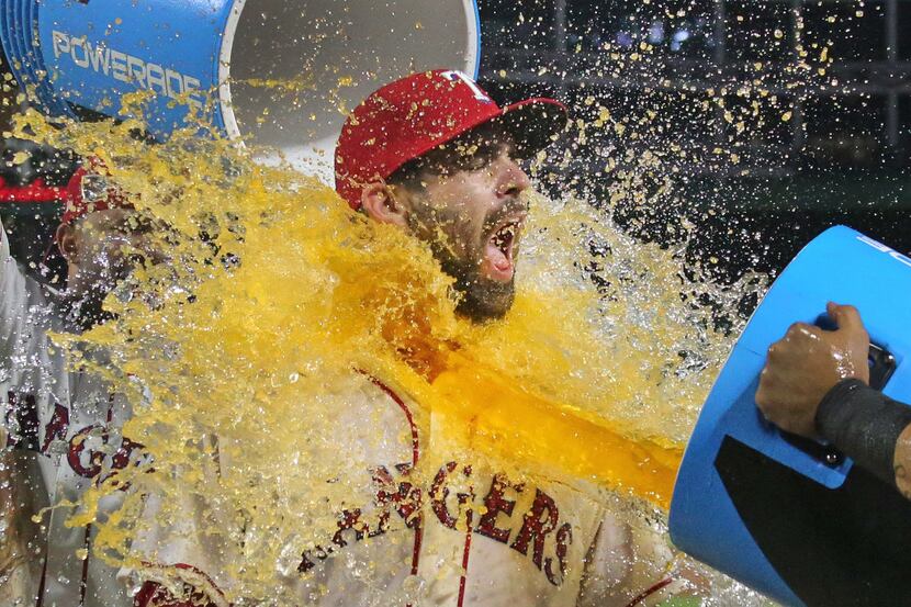 Texas Rangers catcher Brett Nicholas (6) gets the postgame drenching celebrating his first...