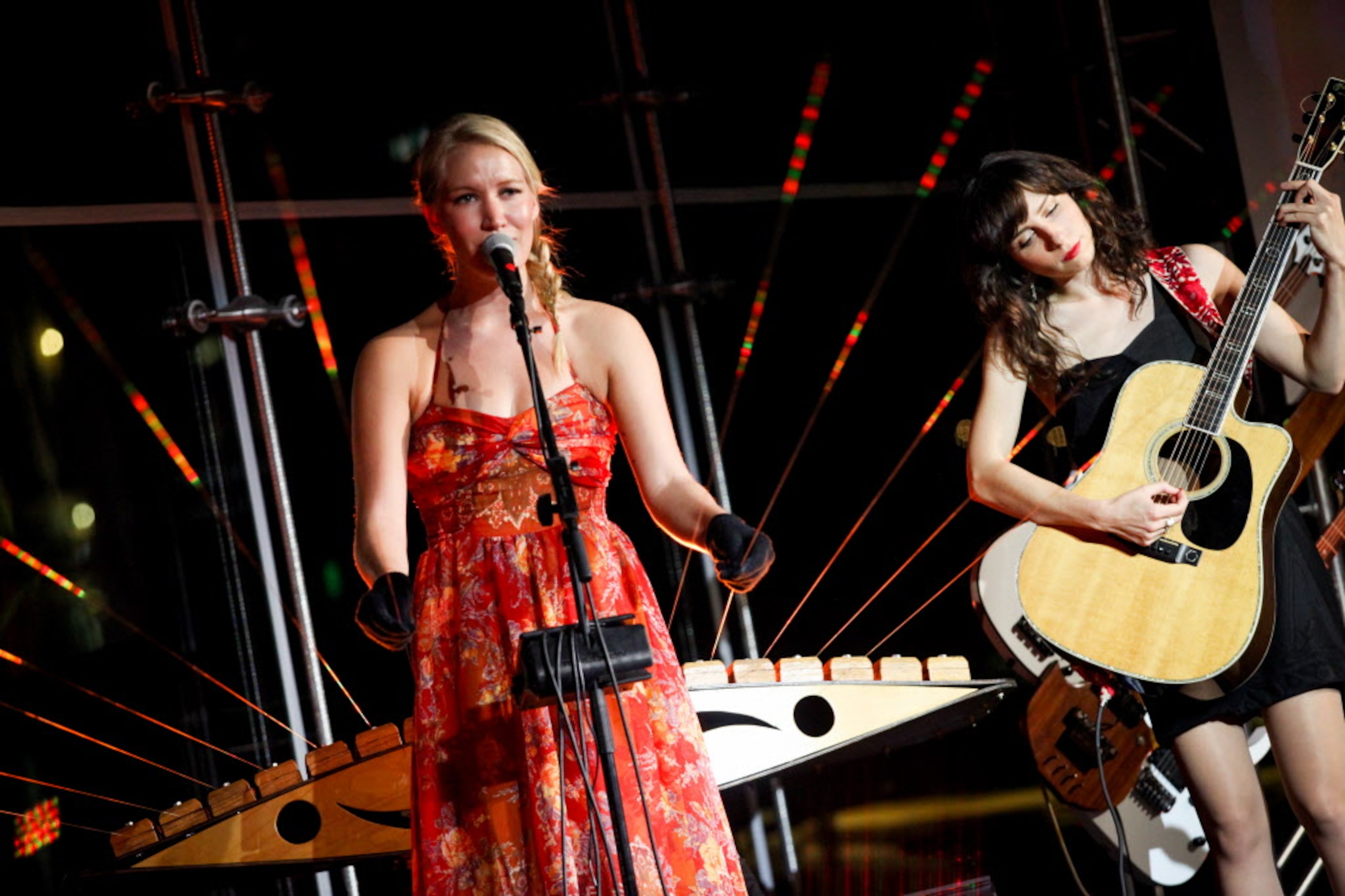 Katie Boeck plays the earth harp while Laena Myers-Ionita plays guitar during the...