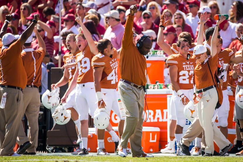 Texas head coach Charlie Strong celebrates after a replay upheld a touchdown run by...