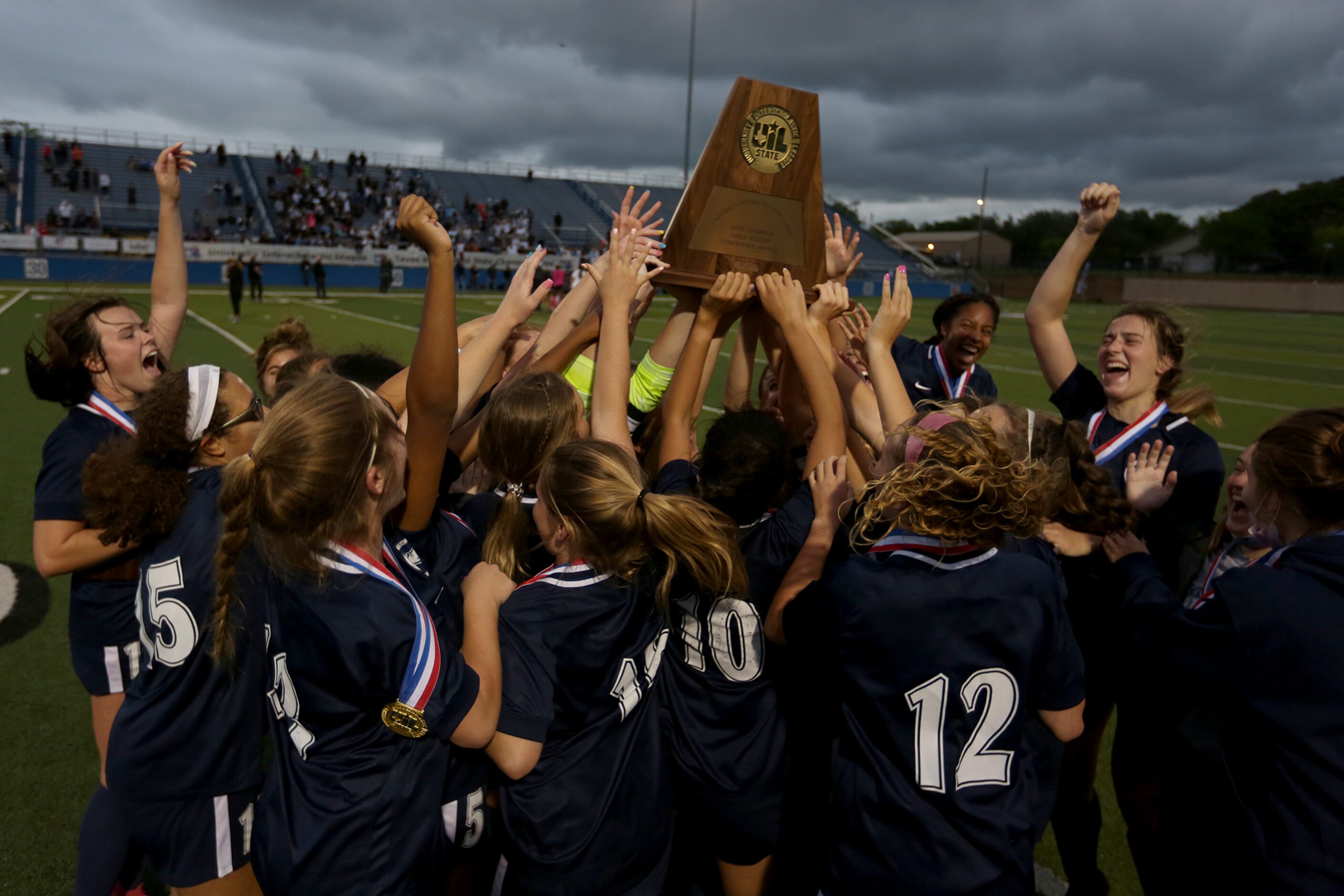 Lewisville Flower Mound players celebrate with the trophy after their UIL 6A girls State...