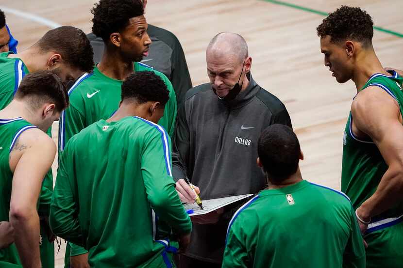 Mavericks head coach Rick Carlisle goes over plays with the team during the first half of a...