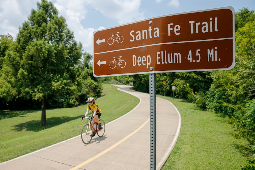 A cyclist rides along the White Rock Creek Trail at White Rock Lake in Dallas. Construction...