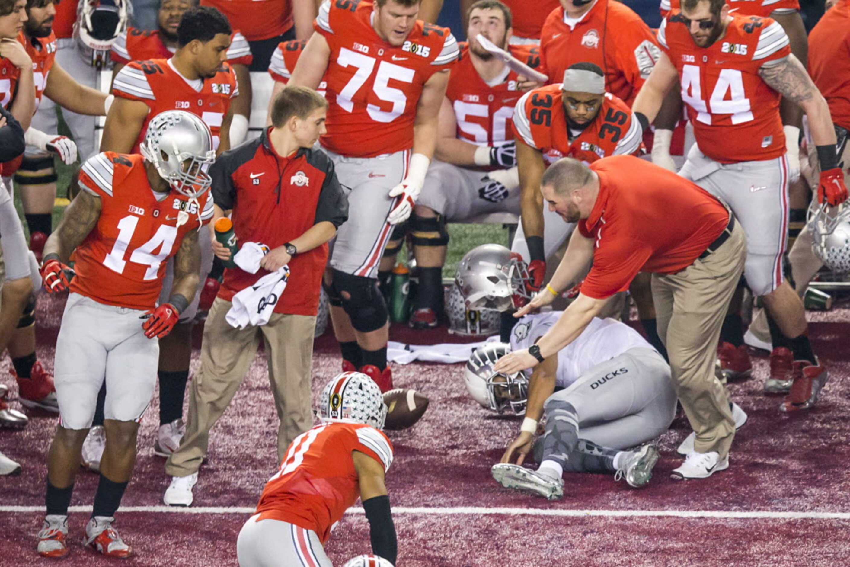 Oregon Ducks quarterback Marcus Mariota (8) slides into the Ohio State Buckeyes bench after...