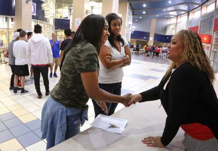 Tia Simmons (right)  visits with staff at Duncanville HIgh School one week before the start...