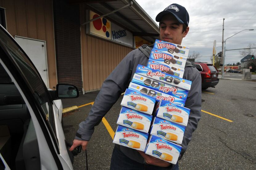 Andy Wagar loads Twinkies, Ho-Hos and cupcakes into a van outside the Wonder Bakery Thrift...