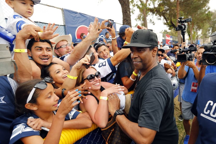 Dallas Cowboys fan and actor Denzel Washington (right) shakes hands with fans following...