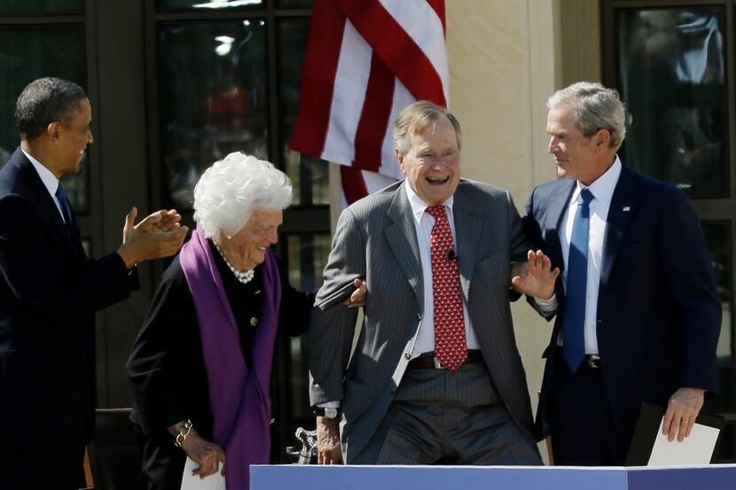 As President Barack Obama applauds, former first lady Barbara Bush, second from left, and...