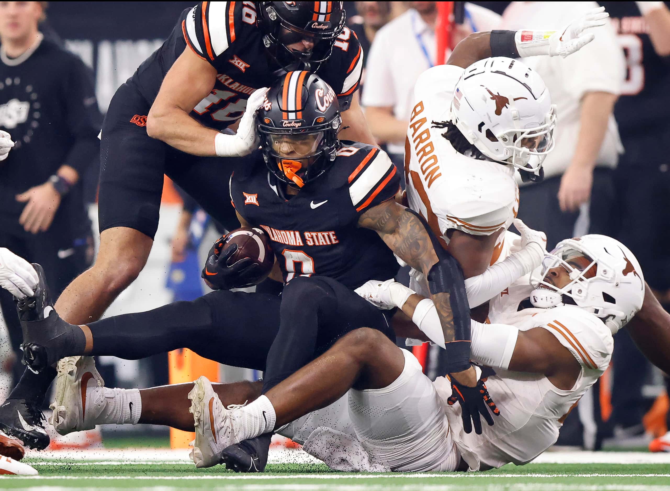 Oklahoma State Cowboys running back Ollie Gordon II (0) is pulled down by Texas Longhorns...