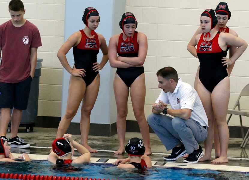 Flower Mound Marcus high school girl’s water polo coach Brandon Dion talks to his team...