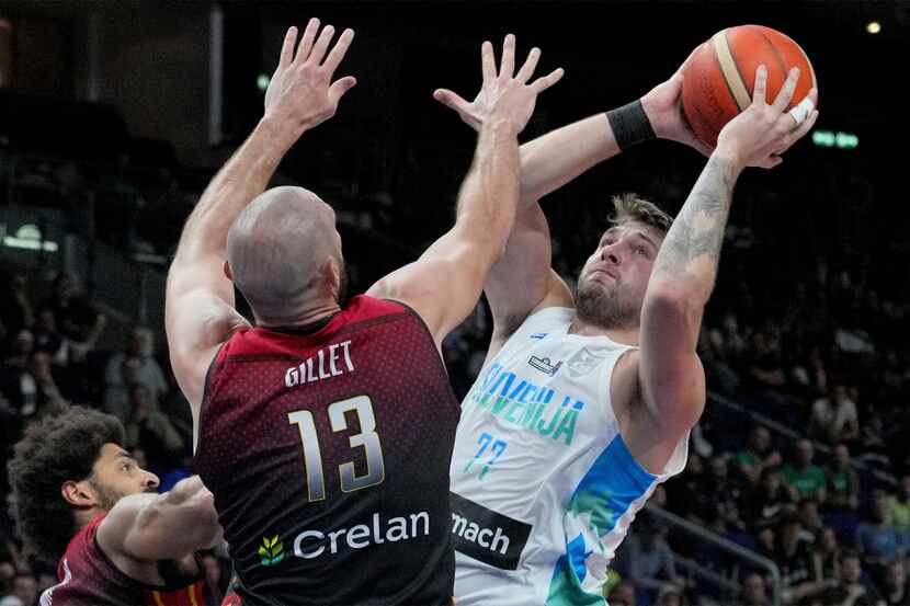 Slovenia's Luka Doncic, right, is challenged by Belgium's Pierre-Antoine Gillet, front,...