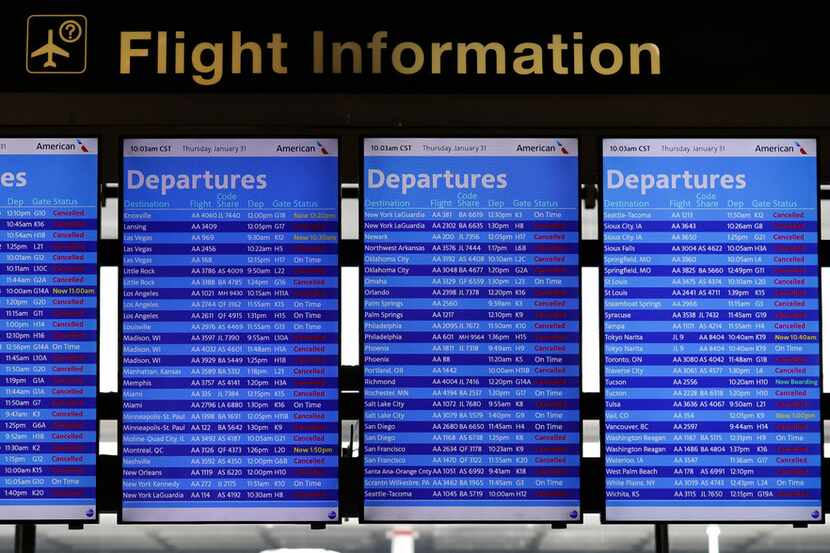 Flight information screens show flight status information at O'Hare International Airport in...