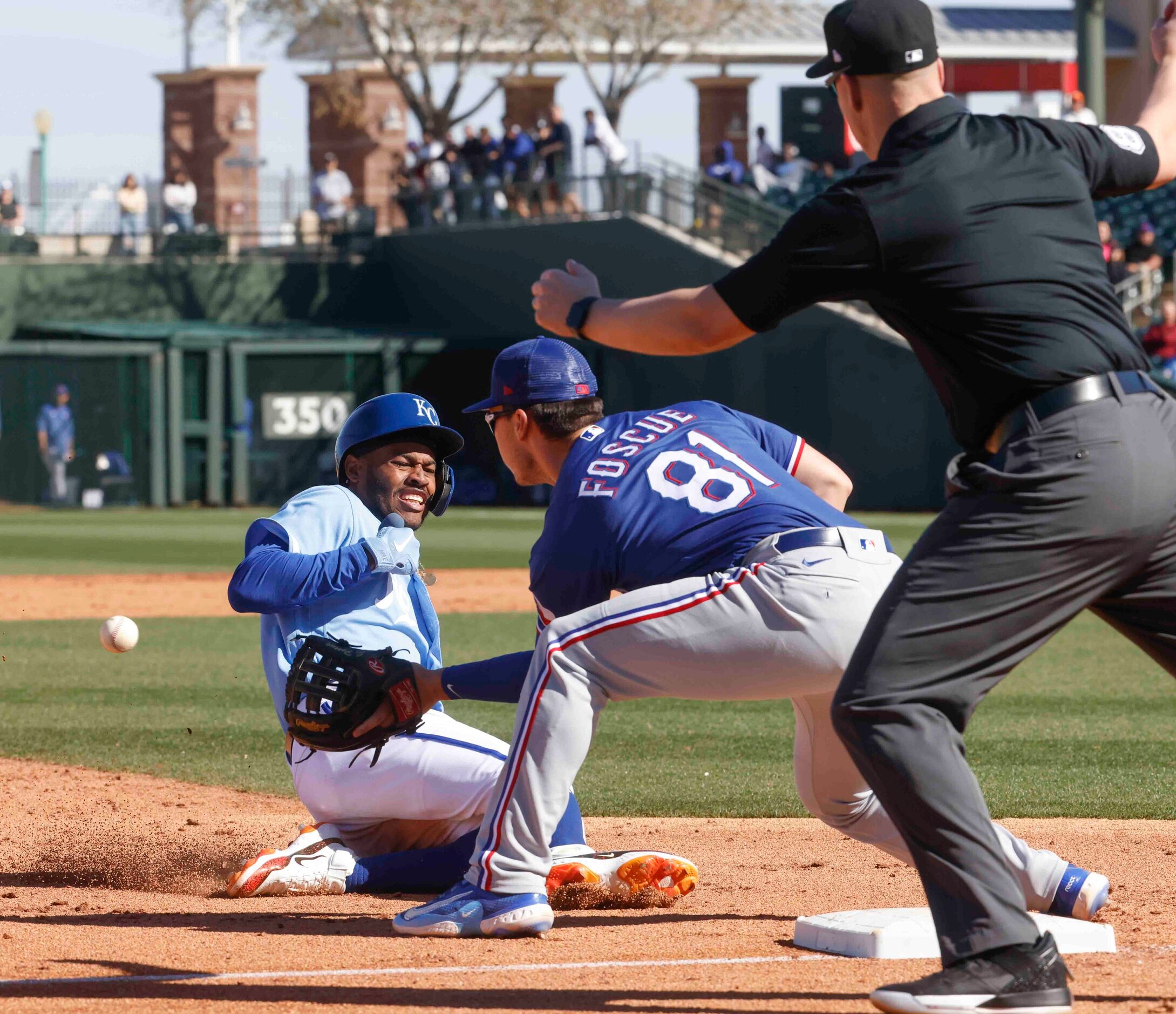 Kansas City Royals Maikel Garcia, left, slides safely into the third base as Texas Rangers...