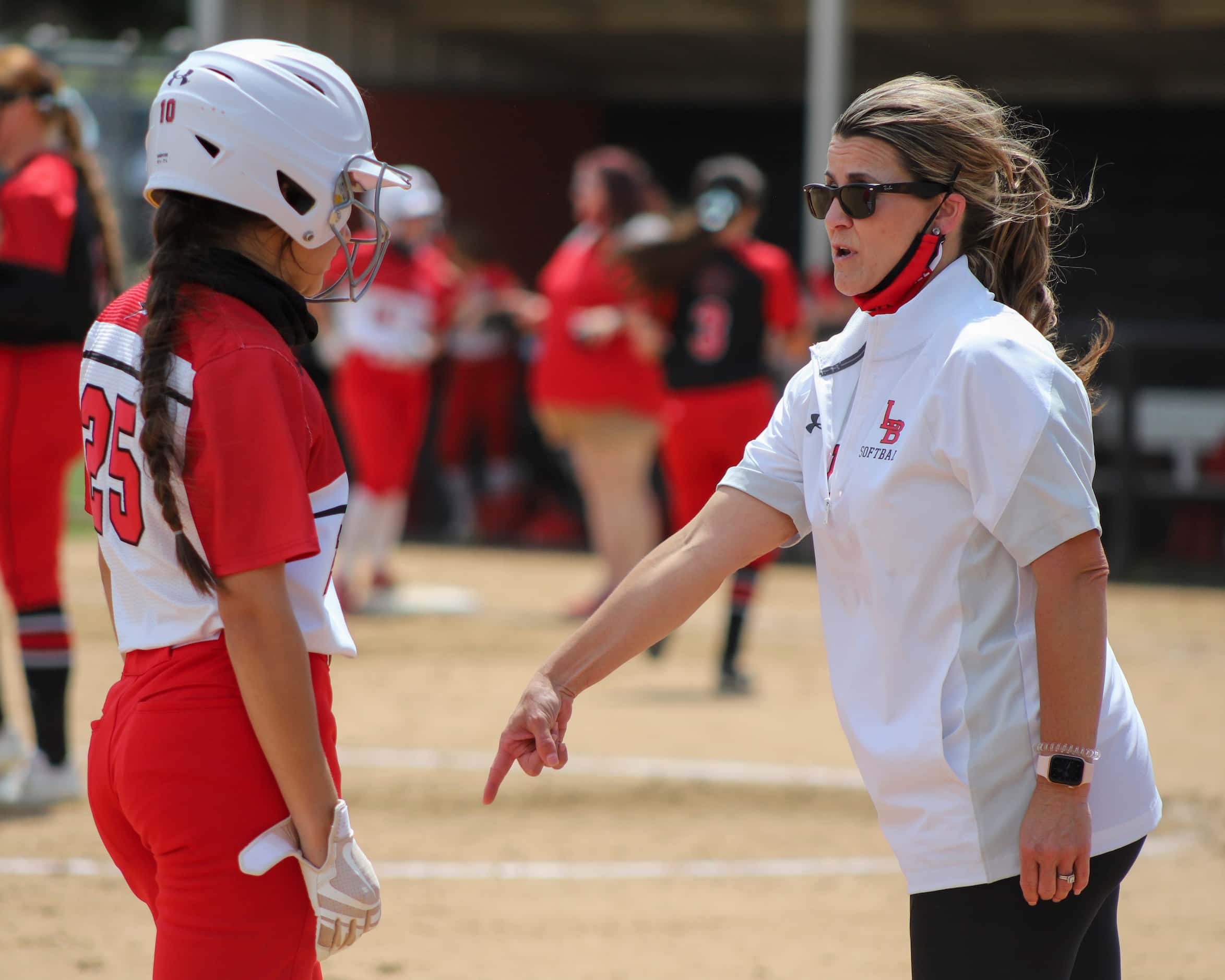 Mansfield Legacy head coach Amie Prater talks with right fielder Haley Brown (25) during a...