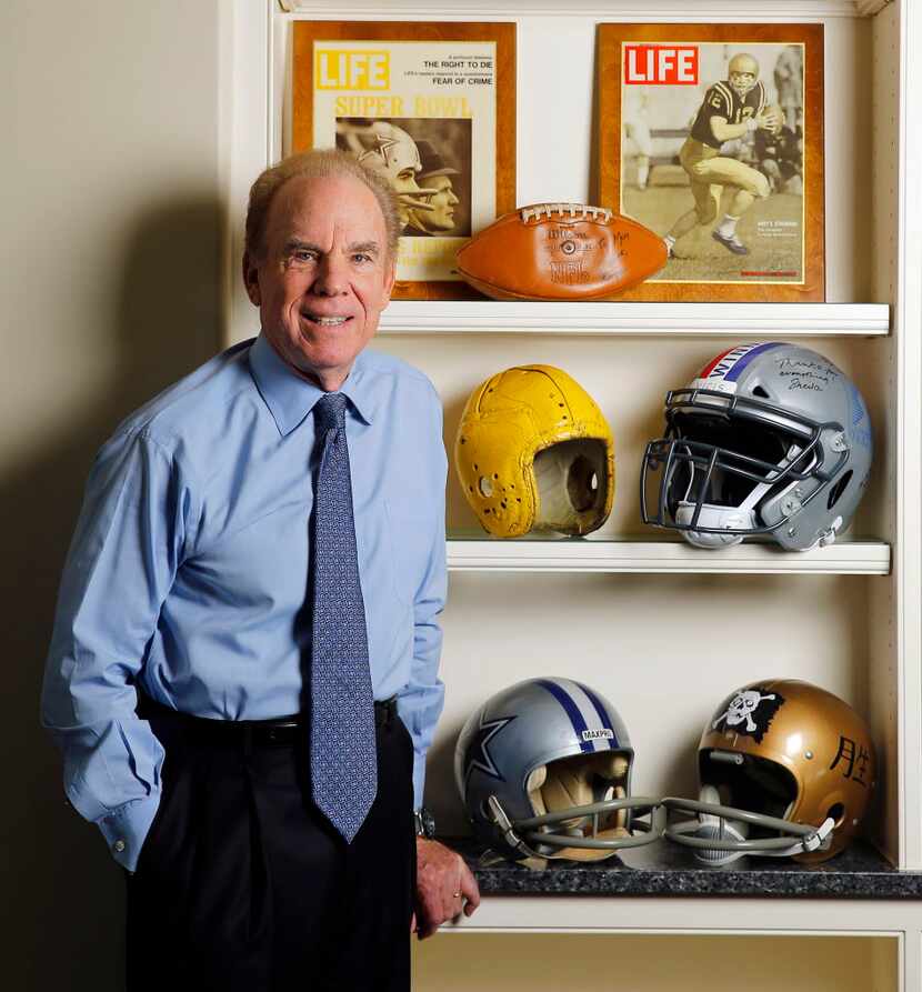 Roger Staubach, a Hall of Fame Dallas Cowboys quarterback, poses with helmets he wore in...
