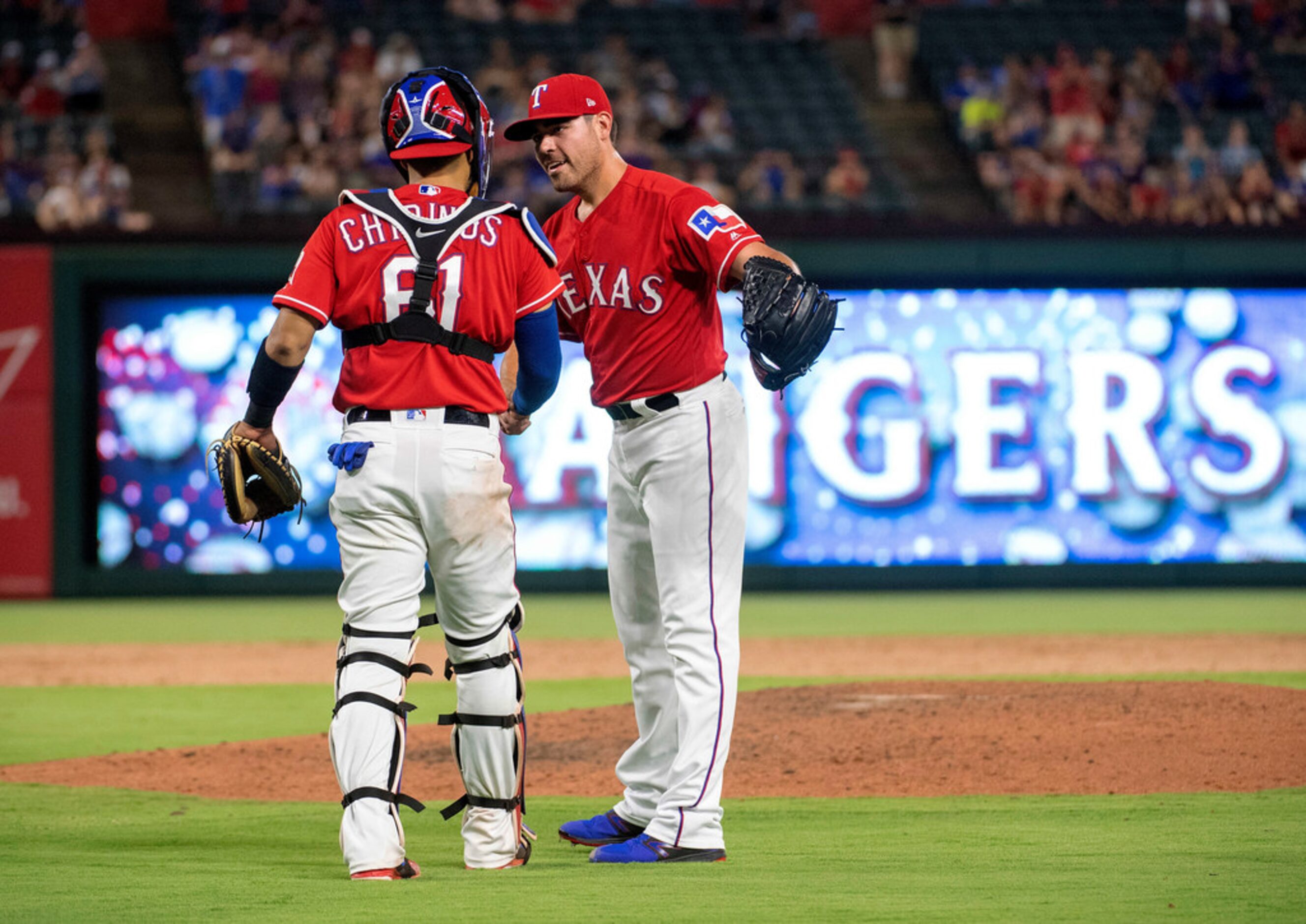 Texas Rangers catcher Robinson Chirinos (61) congratulates relief pitcher Matt Moore after...