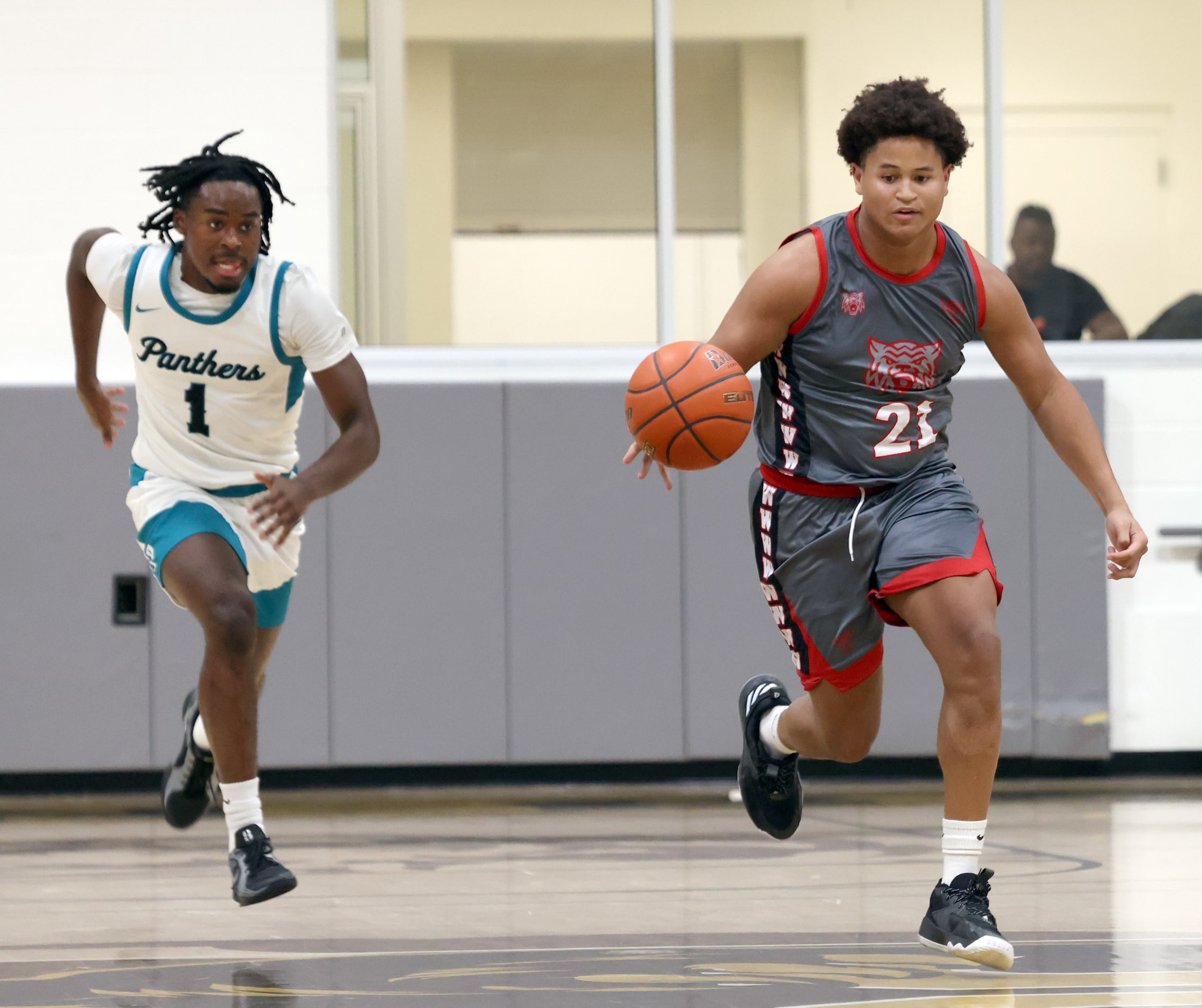 Dallas Woodrow Wilson's Trenton Brown (21), right, brings the ball past mid court as Frisco...