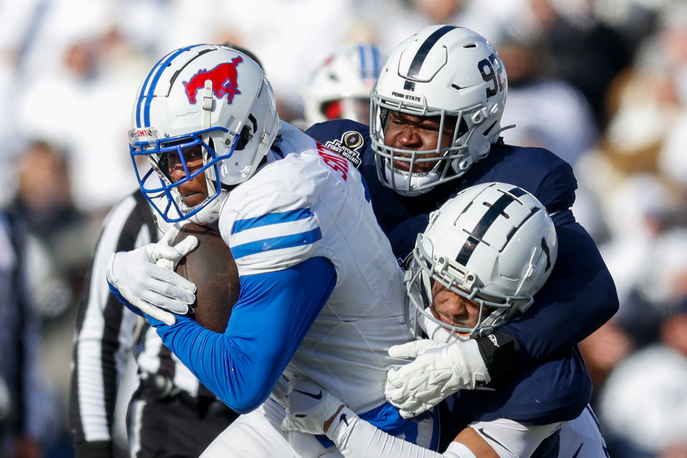 Penn State defensive end Smith Vilbert (92) and safety Jaylen Reed (1) tackle SMU running...