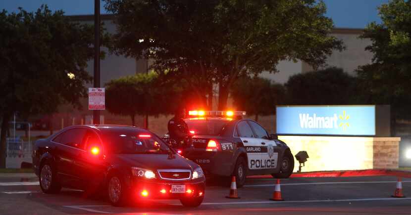 Police outside of an evacuated Walmart on North Garland secure a perimeter after a shooting...