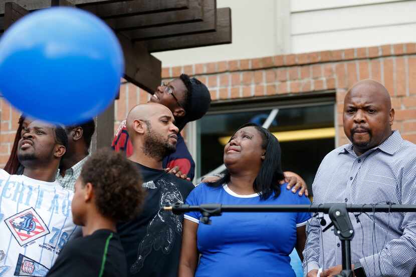 Tina Tyler (center) watches as balloons are released in the sky during a vigil for her son...