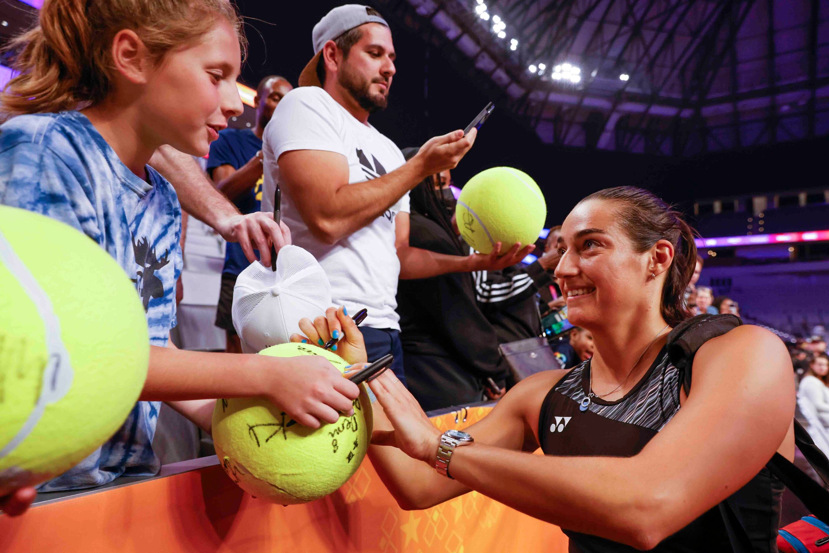 Caroline Garcia of France gives autographs to fans after winning against Coco Gauff of the...