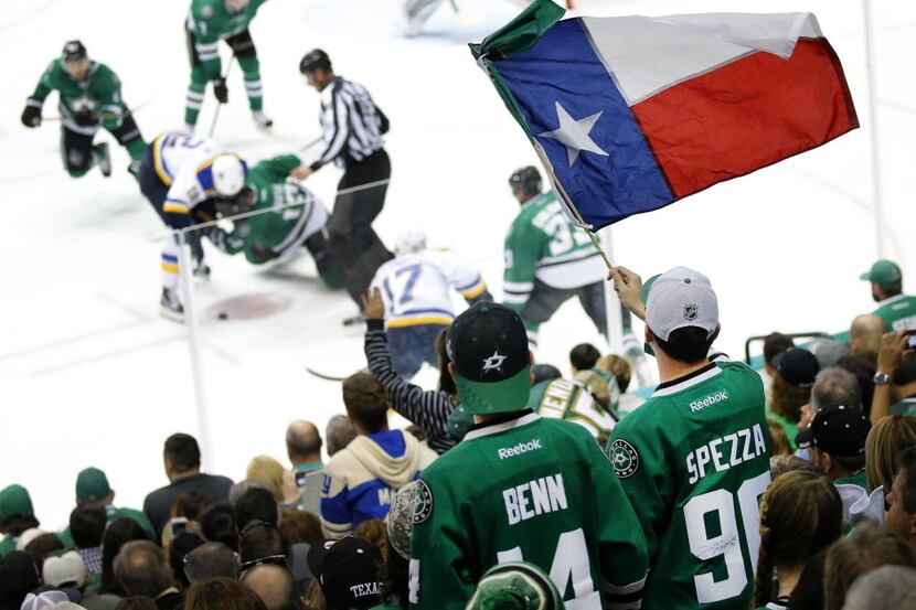 A Dallas Stars fan waves the Texas flag as the Stars and St. Louis Blues face off during the...