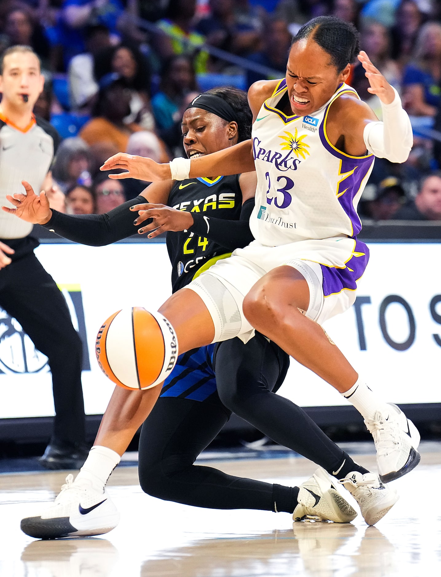 Dallas Wings guard Arike Ogunbowale (24) collides with Los Angeles Sparks forward Azura...