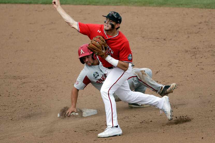Texas Tech shortstop Michael Davis, right, throws to first after forcing out Arkansas'...