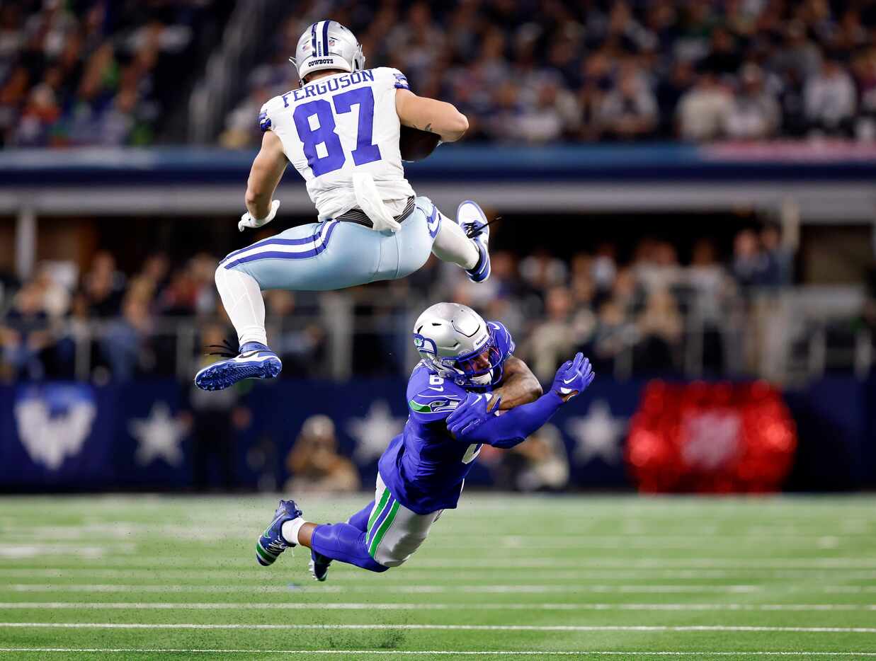 Dallas Cowboys tight end Jake Ferguson (87) hurdles the tackle attempt by Seattle Seahawks...