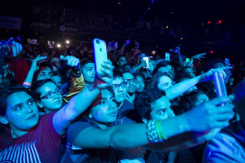 Fans stretch to take cell phone photos of J Cole at the ACL Moody Theater in Austin, Texas...