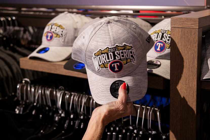 A fan looks at a 2023 Texas Rangers World Series hat on sale at the Grand Slam Team Store in...