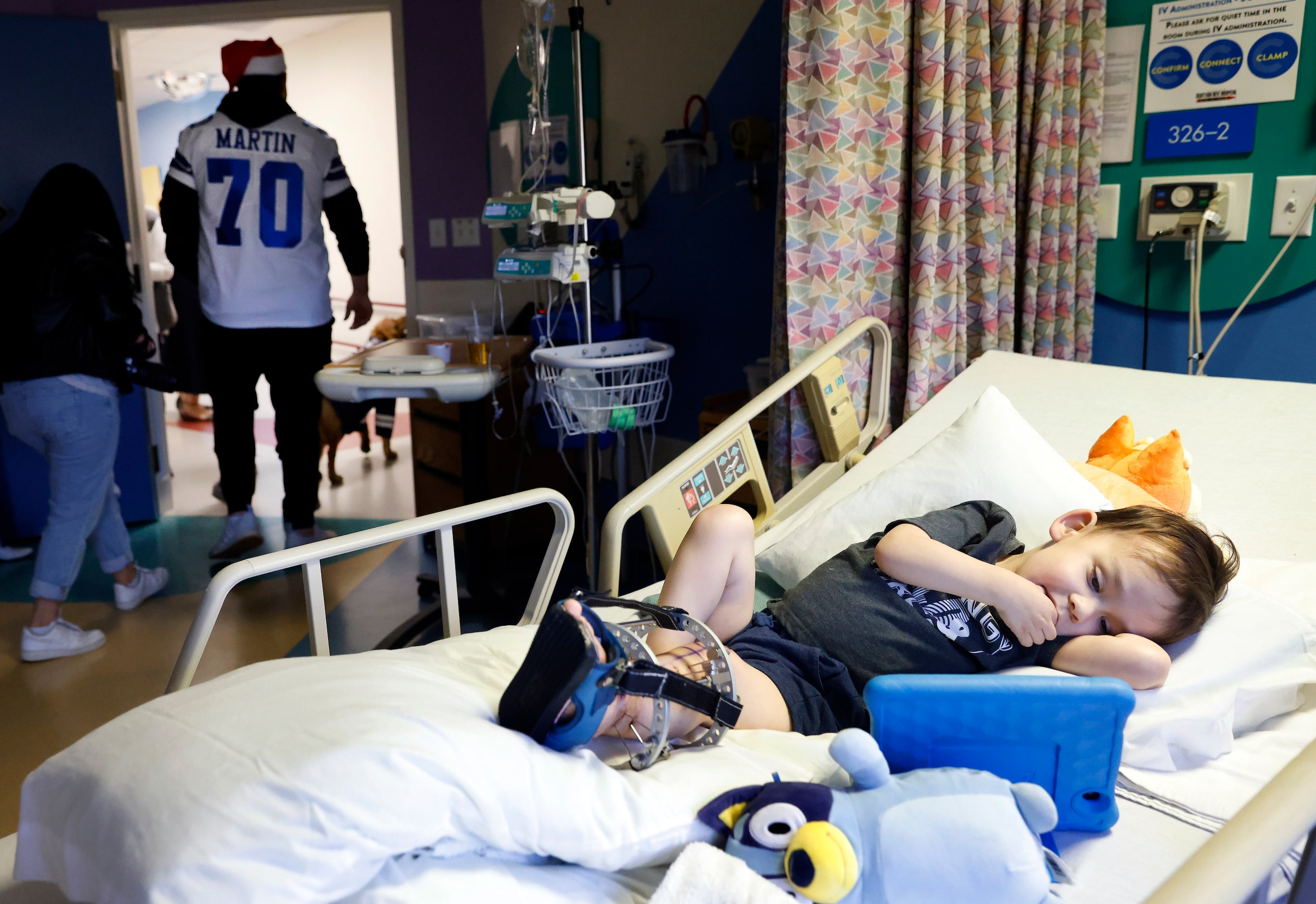 Liam Bannon, 3, of Kyle, Texas watches a cartoon as Dallas Cowboys guard Zack Martin (70)...