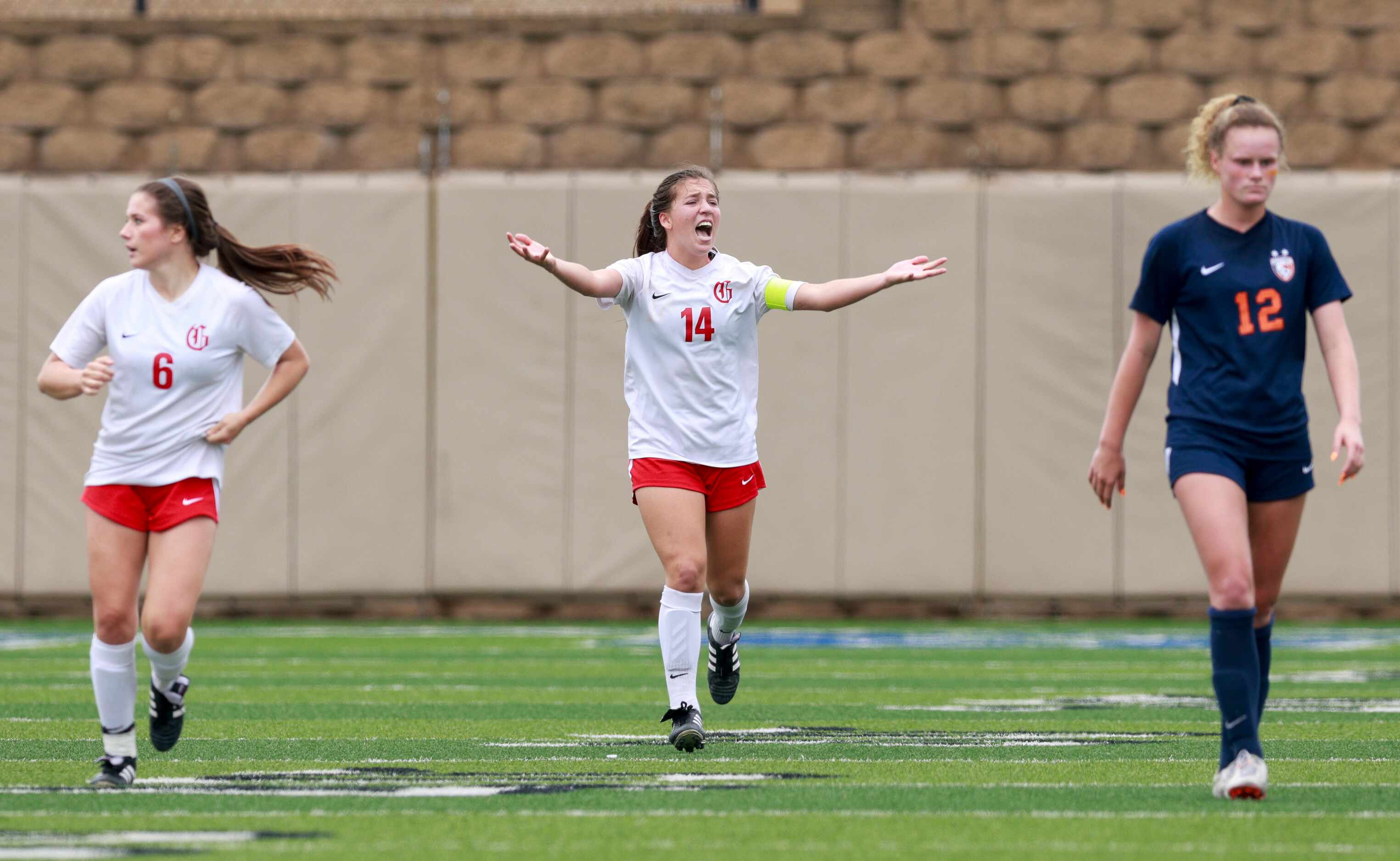 Grapevine forward Theresa McCullough (14) pumps up the crowd after a goal alongside...