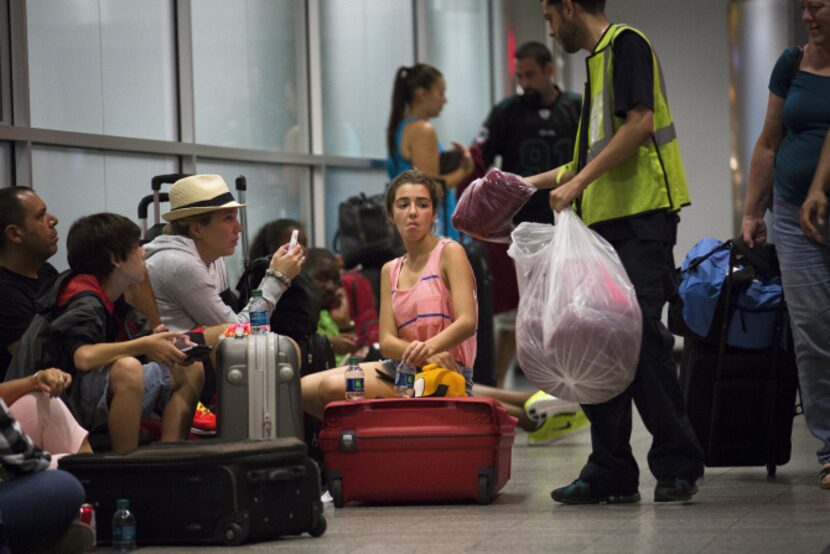 Attendants handed out blankets to passengers stranded when flights were canceled after the...