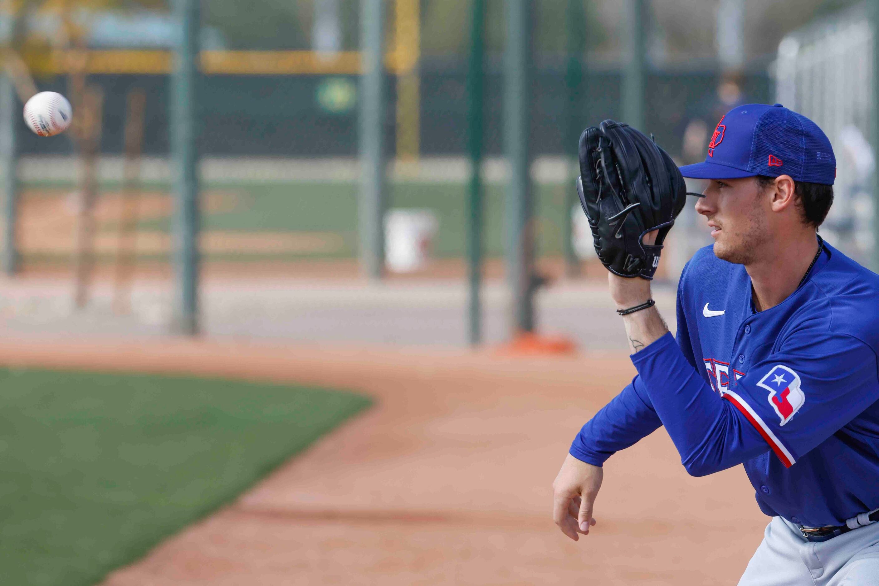 Texas Rangers pitcher Cole Winn catches a ball during a spring training workout at the...