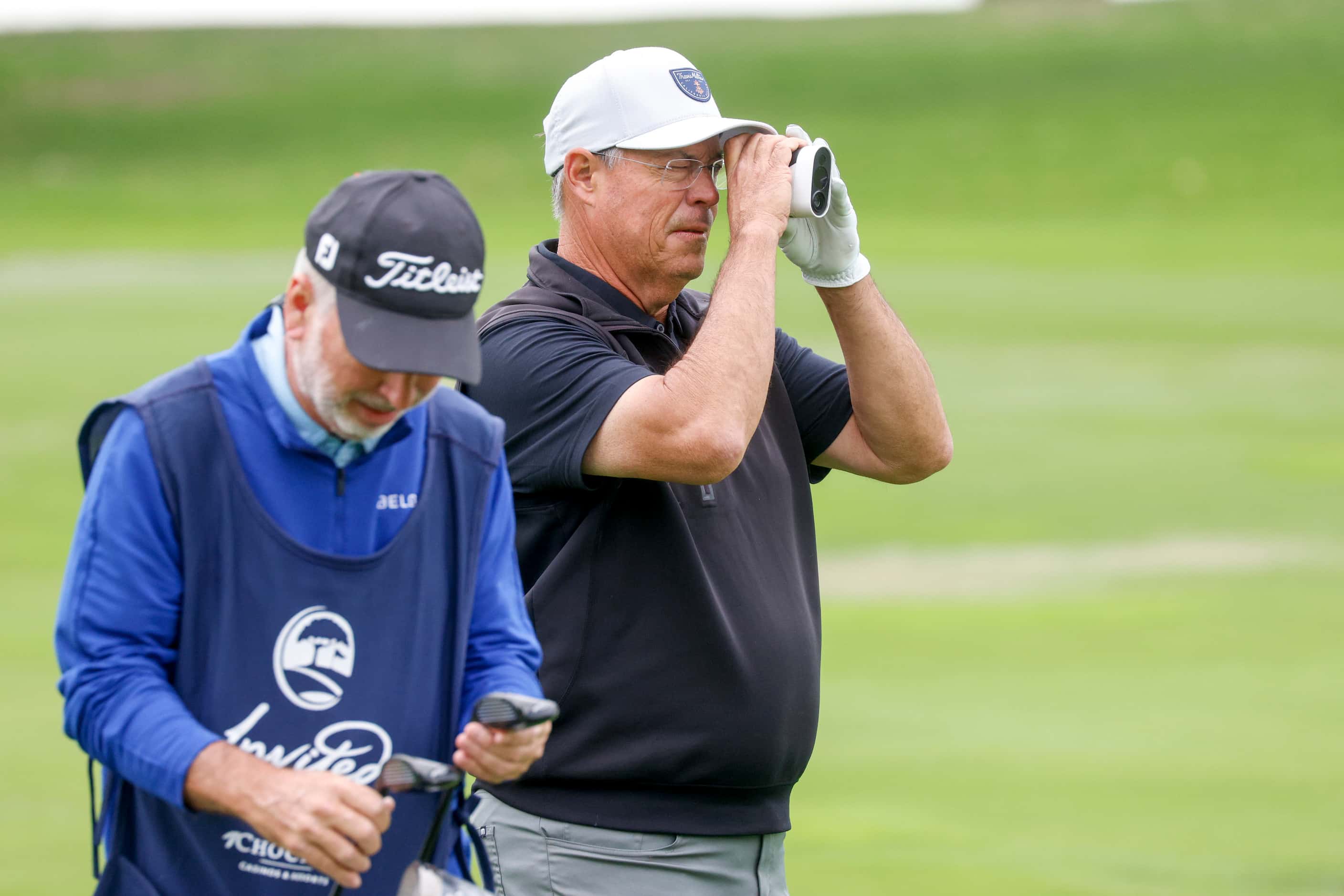 Former MLB pitcher Greg Maddux uses a range finder on the 9th fairway during the first round...