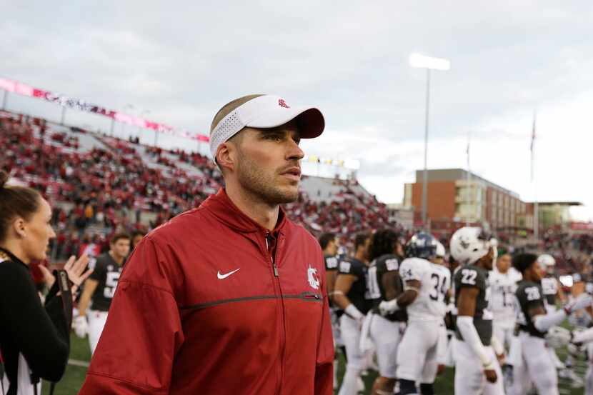 FILE - Alex Grinch, then the defensive coordinator at Washington State, walks onto the field...