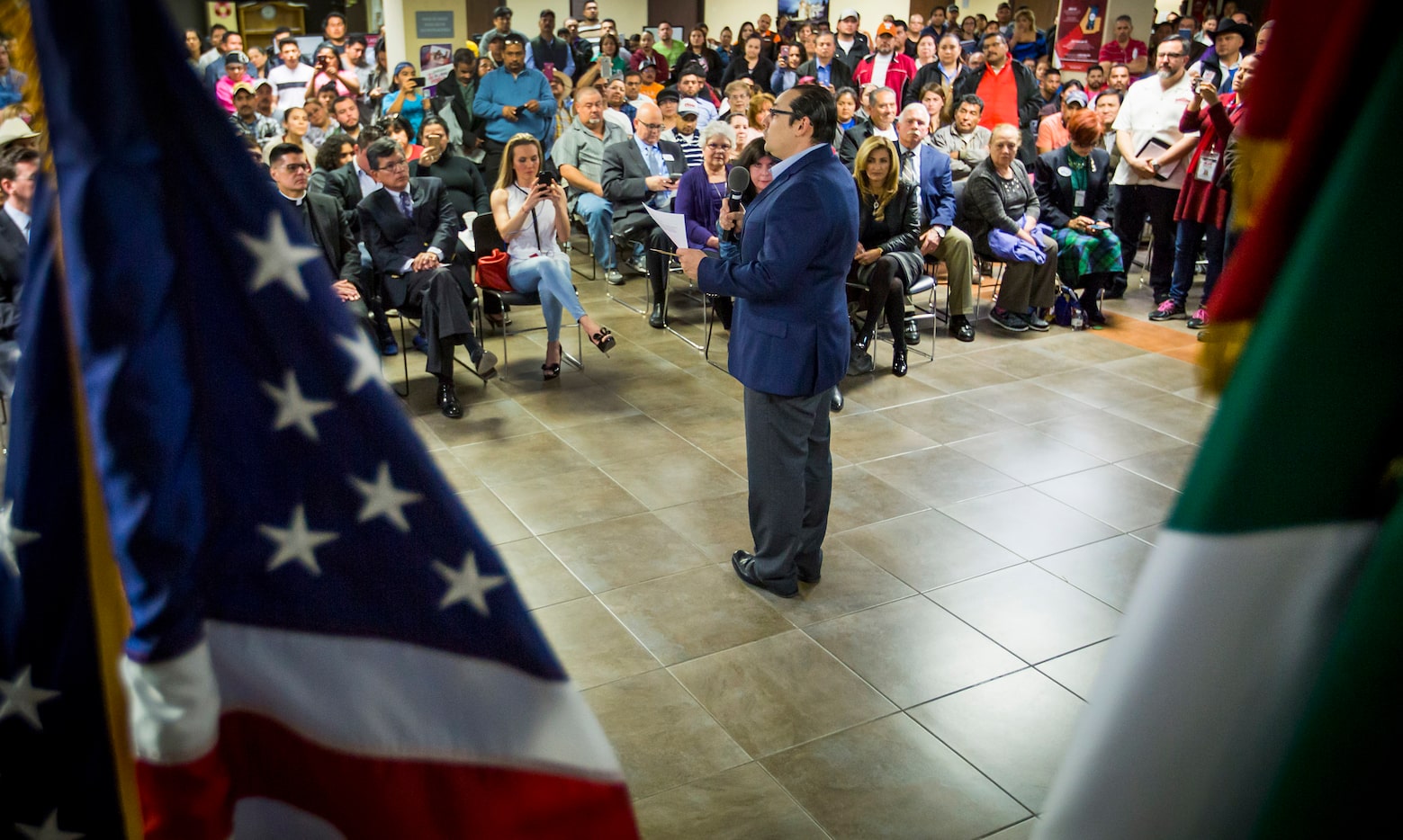 Francisco de la Torre, the Mexican consul general in Dallas, is framed by the flags of the...