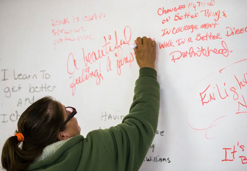 Frances Martinez writes a note on a whiteboard after a group session. (Ashley Landis/The...