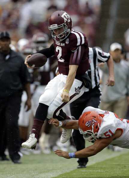 Texas A&M quarterback Johnny Manziel (2) leaps as Sam Houston State linebacker Eric Fieilo...