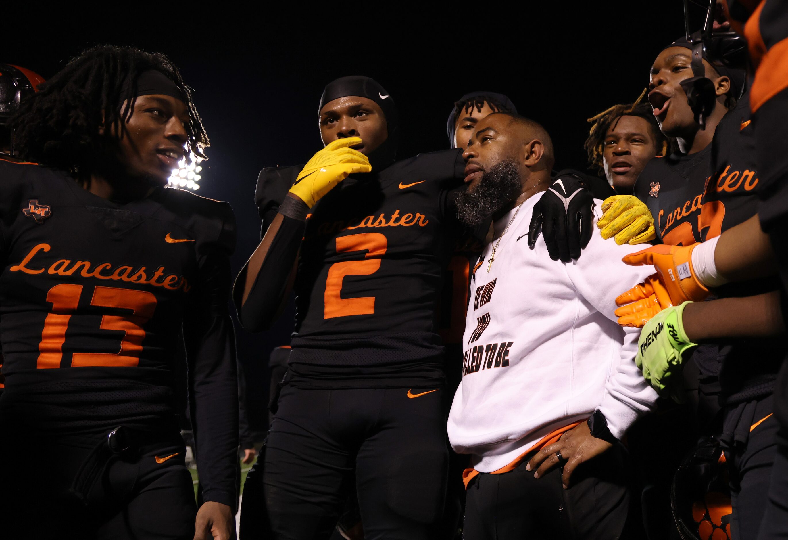 Lancaster players surround their emotional head coach, Leon Paul, lower center right, after...