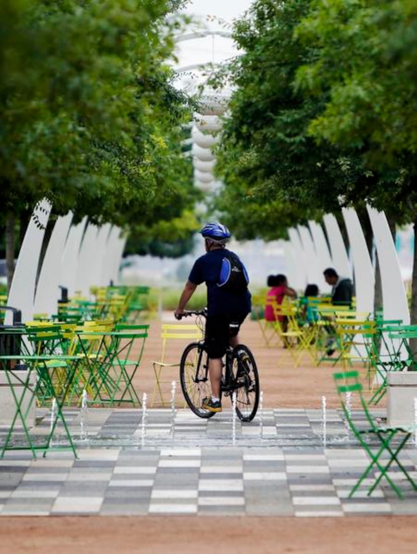 
A cyclist rides along a path at Klyde Warren Park on Monday.
