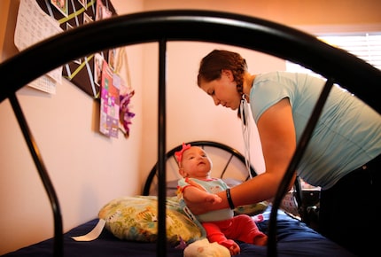 Desiree Wilber finishes changing Lillian's diaper in her private bedroom at Santa Maria...