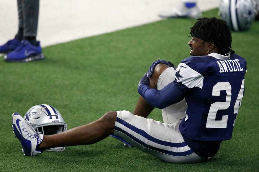 Dallas Cowboys cornerback Chidobe Awuzie (24) grabs his right leg after intercepting a pass...