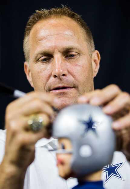 Former Dallas Cowboys defensive tackle Chad Hennings signed a bobblehead for a fan during...