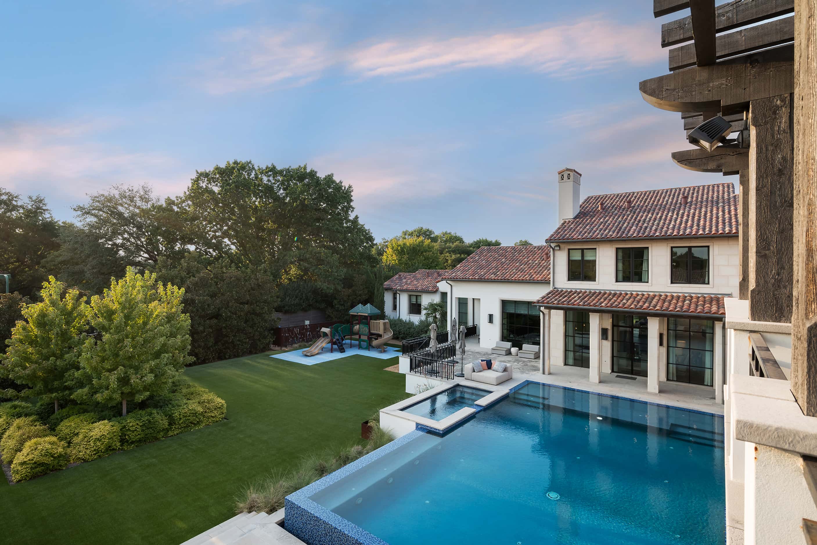 A high-level view of the property's backyard shows the outdoor living spaces, a pool and a...