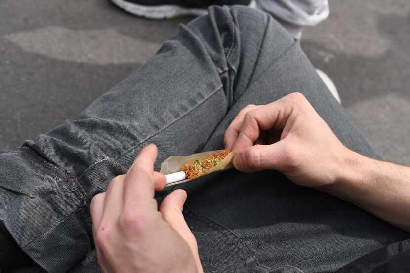 A person rolls a joint. 