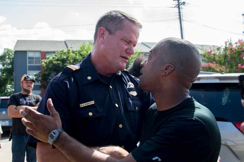 Officer W.C. Humphrey shake hands and embrace with Ty Hardaway, 44, of Dallas during the...