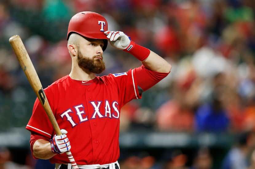 Texas Rangers catcher Jonathan Lucroy (25) adjusts his helmet as he goes up to bat in the...
